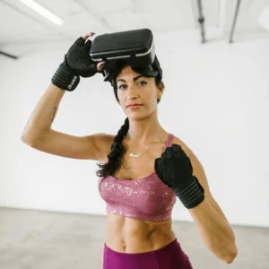 Athletic woman in a gym wearing a VR headset and workout gear. Perfect for modern lifestyle and fitness concepts.